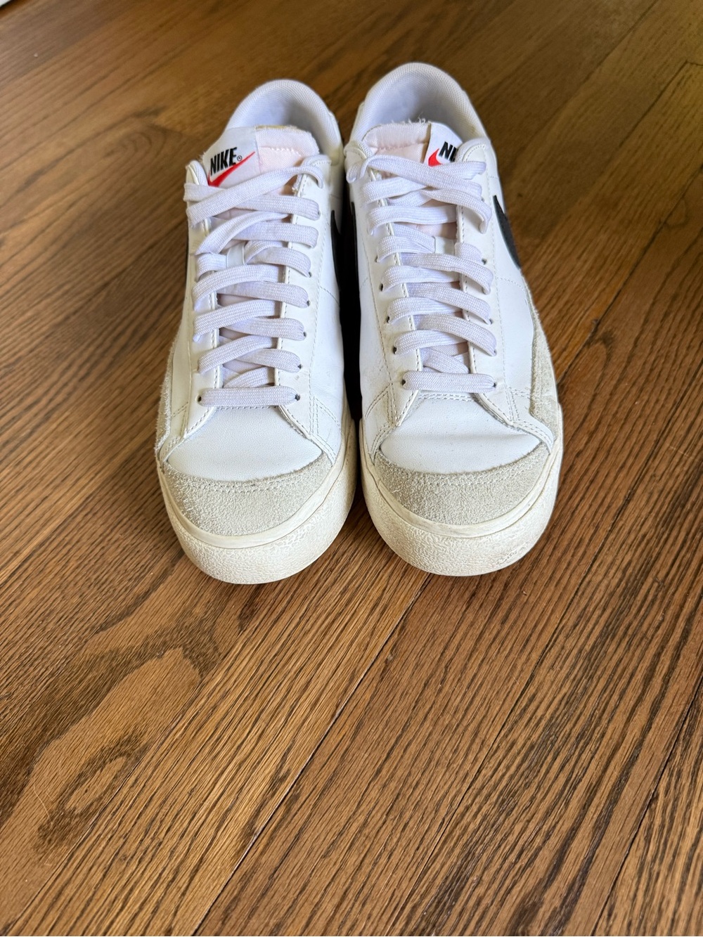 Nike White Sneakers with Black Swoosh and Cream Accents.